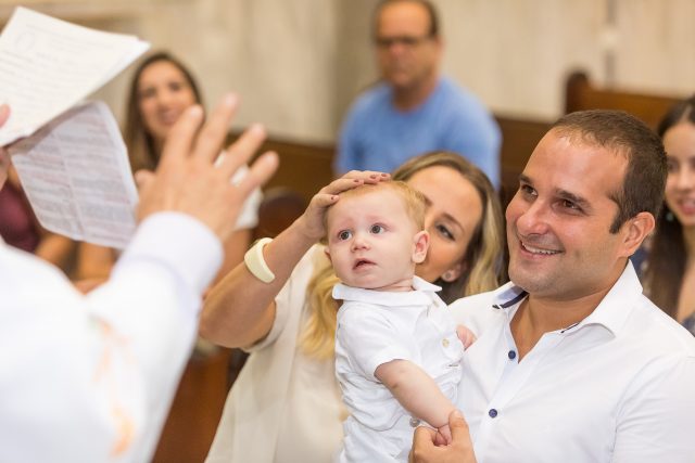 bebê sendo batizado pais sorrindo fotografia de festas infantis fotógrafa de batizado sp são paulo