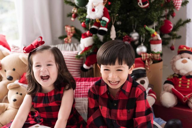 fotos de família irmãos em estúdio fotográfico laura alzueta vestidos de xadrez em cenário decorado natalino